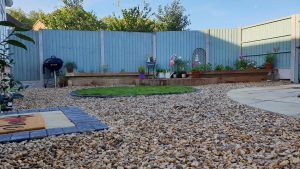 garden with decking, grass, stones and patio